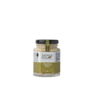 A hexagonal glass jar with a black label branded Truffle Hill. Label describes Truffle Aioli